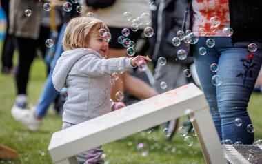 Child catching bubbles at Egg Rolling event.