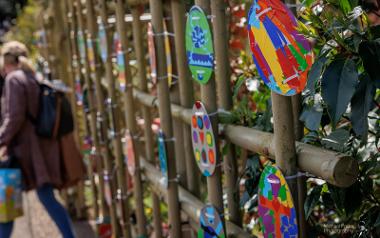 Close up of colourfully decorated eggs along Avenham Park's Japanese Garden fence.