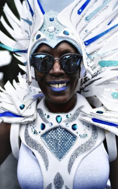 Woman at 2018 Caribbean Carnival dressed in sparkly white and blue outfit, with blue lipstick.