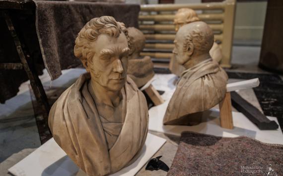 Busts from The Harris' collection arranged on floor ready for storage.