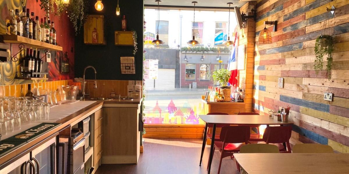 A view of the outside from inside Itsy's Street Food restaurant with seating area