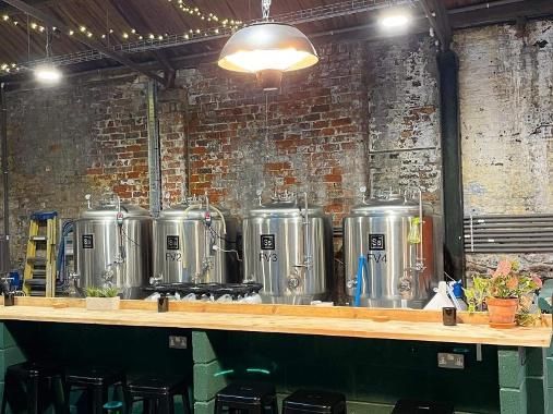 Four brewing tanks behind a bar at Chain House Brewing Co.