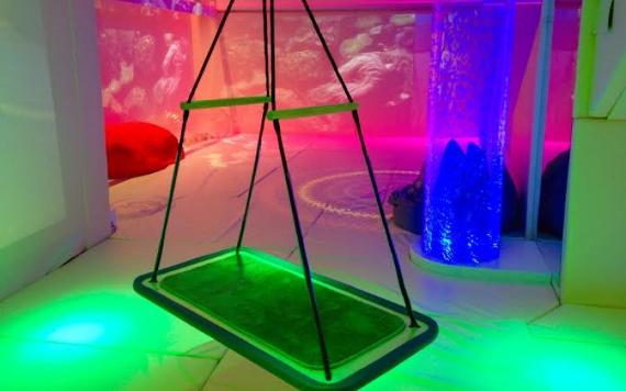 The Space Centre's Sensory Room 2 featuring a large swing and lots of padded floor space with underwater wall projections