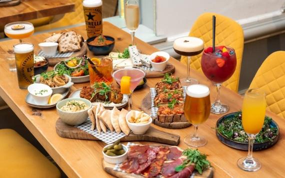 A bottomless brunch serving at Fino Tapas featuring lots of charcuterie meats, breads, croquettes and alcoholic drinks