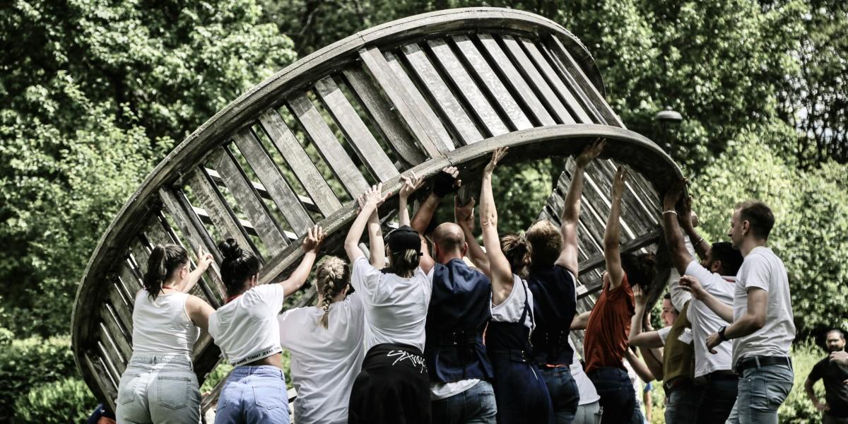 People holding up a giant wheel People holding up a giant wheel