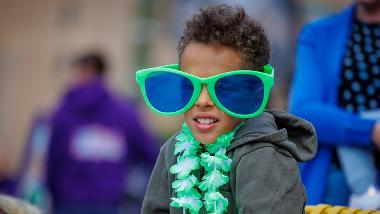 Child wearing oversized green glasses