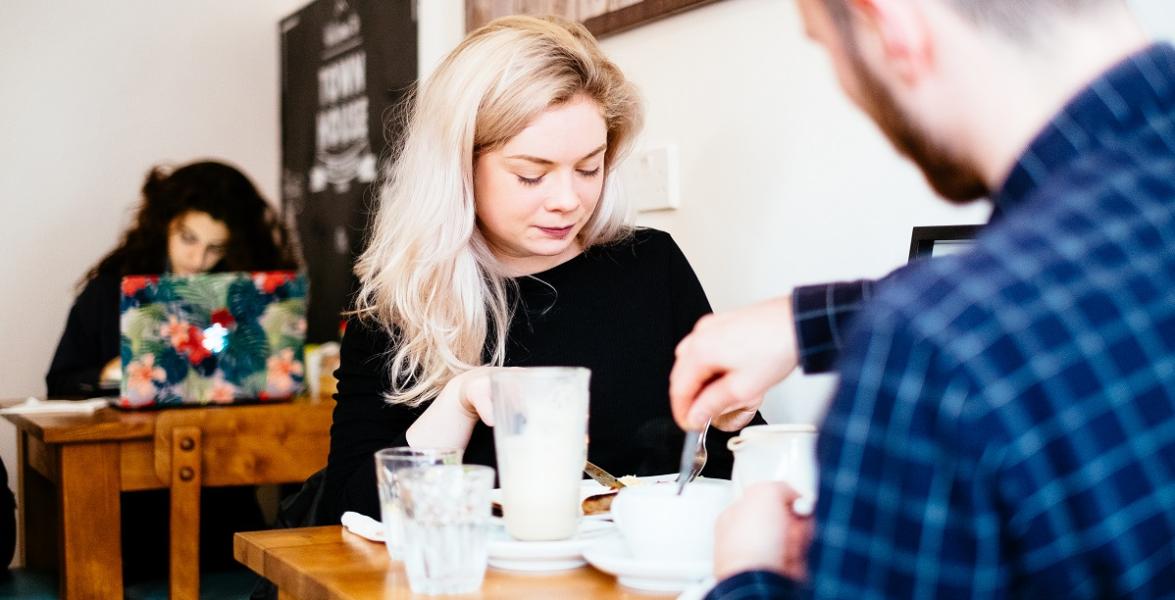 Young couple enjoying coffee and cake in Preston