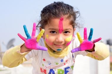 Child with colourful paint on hands