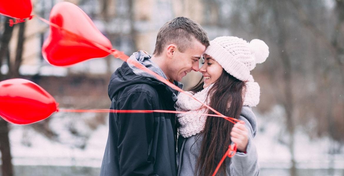 Couple hugging and holding heart balloons