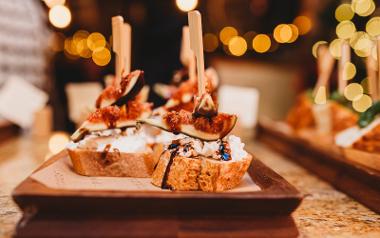 A close up of Goats cheese and cherry Pintxos served on a wooden plate