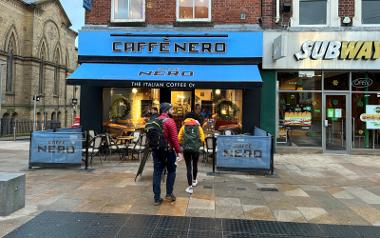 Outside Caffé Nero looking at the entrance with people walking inside