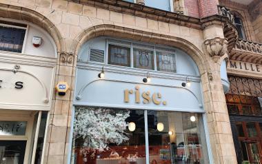 A view of the outside signage and front windows of Rise at Miller Arcade