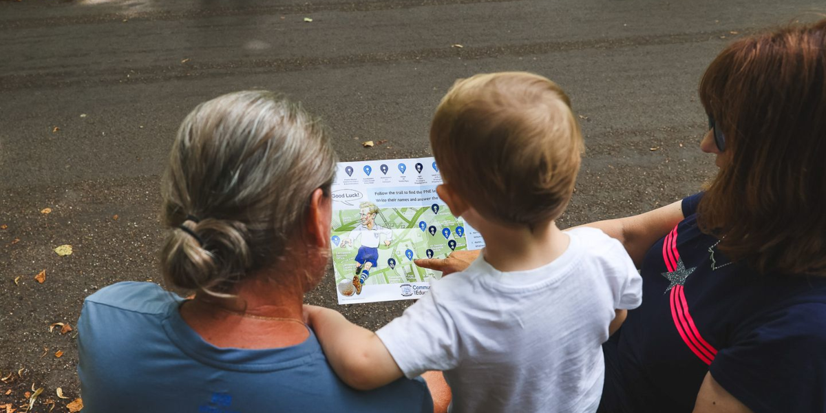 A small family look at a map of art locations for Preston North End Football Club