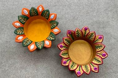 Two clay flower shaped pots painted in bright colours