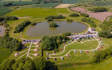 In the sky looking down at the Stanley Villa Farm camp site and lake