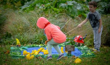 Hook a duck, two children playing the game at Encounter Festival.