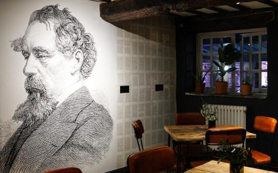 A wall mural of Charles Dickens inside Lost Bar and Pizzeria