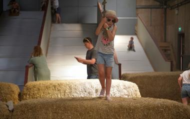 Child playing on rope swing in the play barn