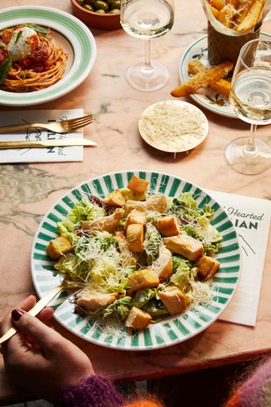 A plate of Caesar salad from ASK Italian sprinkled with cheese and a side of fries