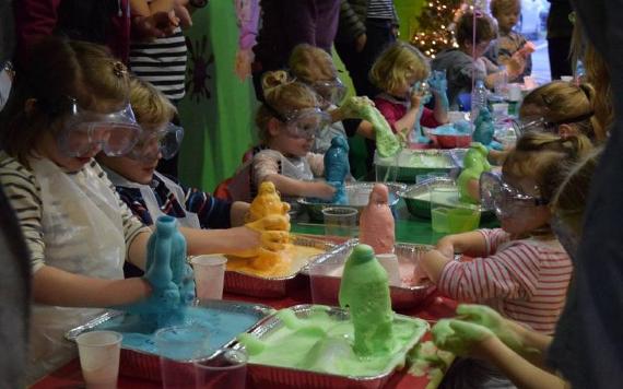 Table of children making coloured eruptions in bottles.