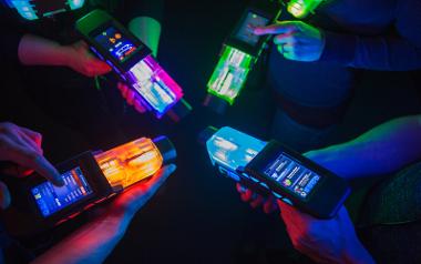 A close up of four people interacting with their laser guns inside Laserforce Preston