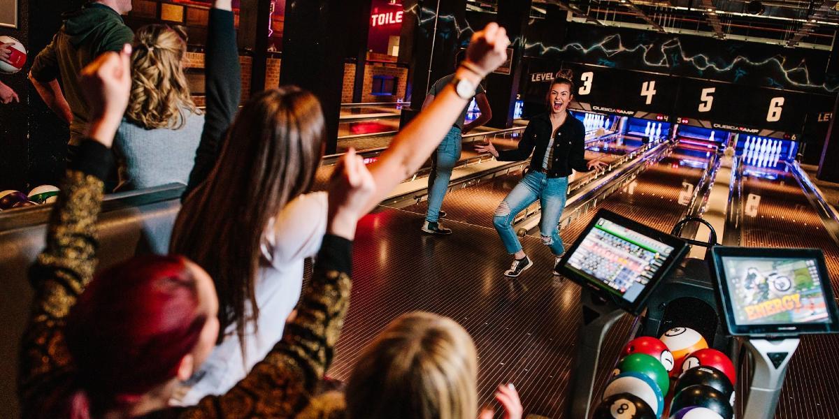 Main image: Group celebrating a strike during a bowling game at Odin's Bowl. Group celebrating a good bowl during a bowling game at Odin's Bowl.