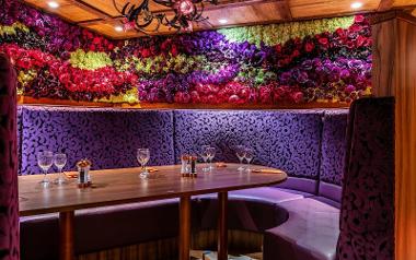 Booth with walls covered in colourful flowers at Flower Bowl restaurant.