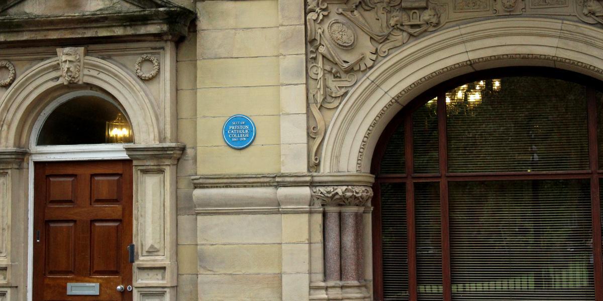 Blue plaque and doorway on old Preston Catholic College building.