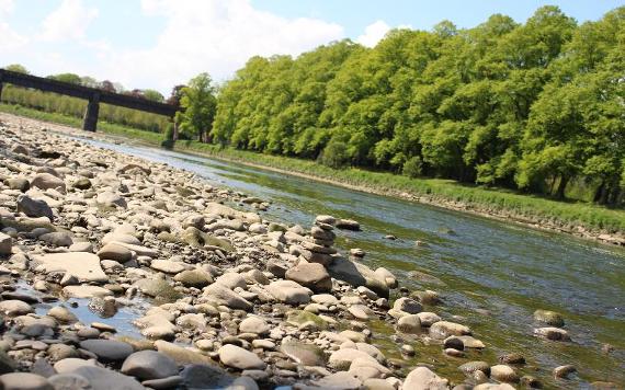 Rocks balanced on top of one another on rocky bank of Rive Ribble.