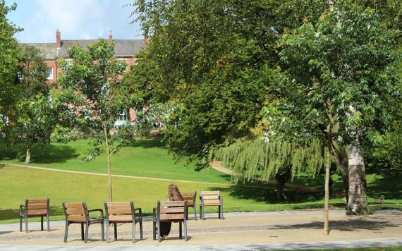 Woman sat on chair in Winckley Square Garden's central seating area.