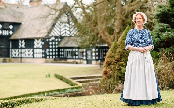 Tour guide in period costume stood outside Samlesbury Hall.