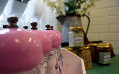 Close-up of pink salt and pepper shakers and preserves on sale inside Rosemary on the Park cafe.