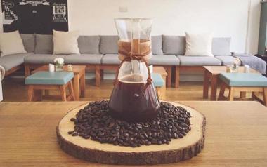 Coffee jug on pile of coffee beans with Town House upstairs seating in background.