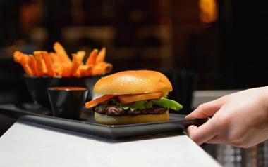 IceBurg burger and fries on a serving tray being placed on a counter