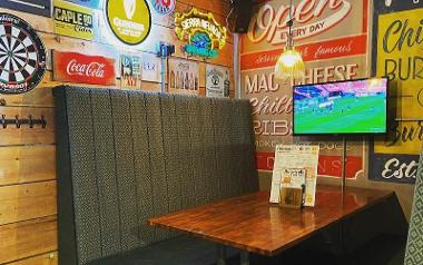 Booth with TV and American sport decor inside Wings & Beer Co.