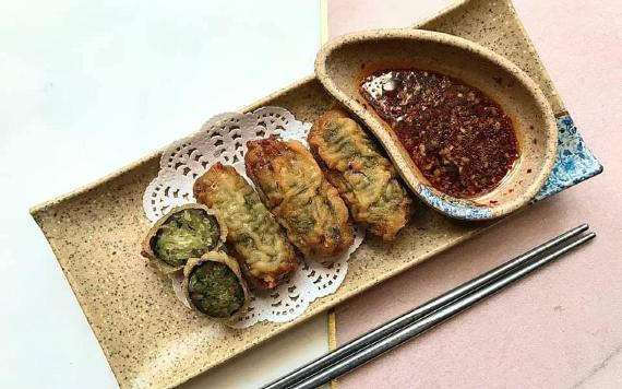 Korean dish arranged on plate with chopsticks inside Kimji restaurant.