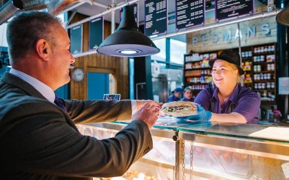 Man purchasing sandwich from Redmans counter.