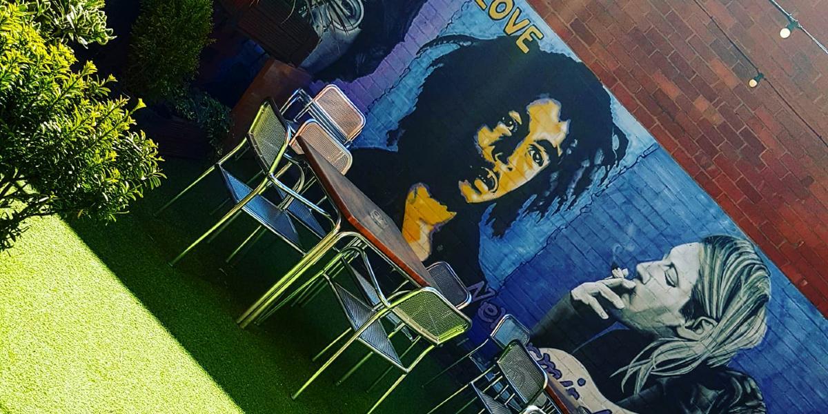 Main image: Hartleys Wine Bar beer garden with Kurt Cobain and Bob Marley artwork on walls. Hartleys Wine Bar beer garden with Kurt Cobain and Bob Marley artwork on walls.