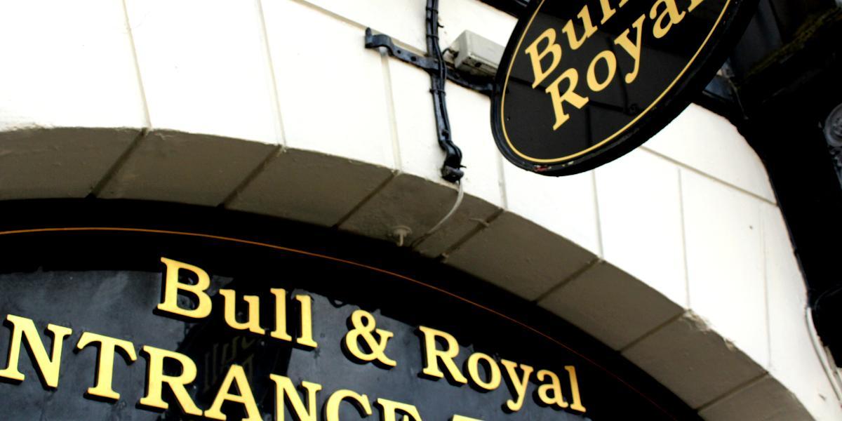 Close-up of The Bull and Royal sign above archway entrance.