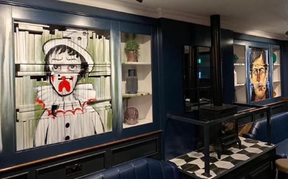 Clown portrait and seating area inside The Northern Way.