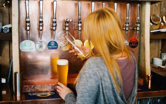 Bartender pulling a pint behind The Orchard bar.