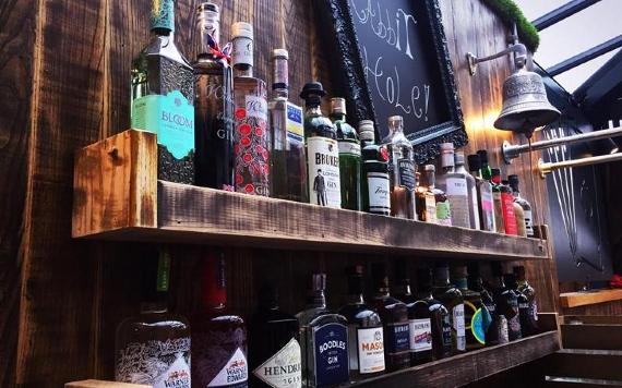 Shelves of Gin behind The Rabbit Hole's bar.