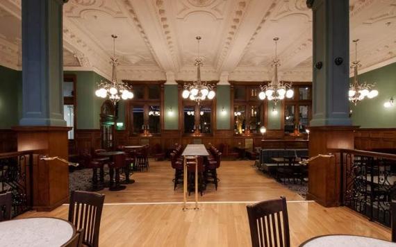 The Twelve Tellers large seating area with high ceilings and chandeliers. 