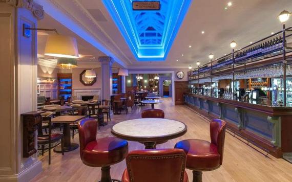 The Twelve Tellers bar and seating area with ceiling lit in blue.