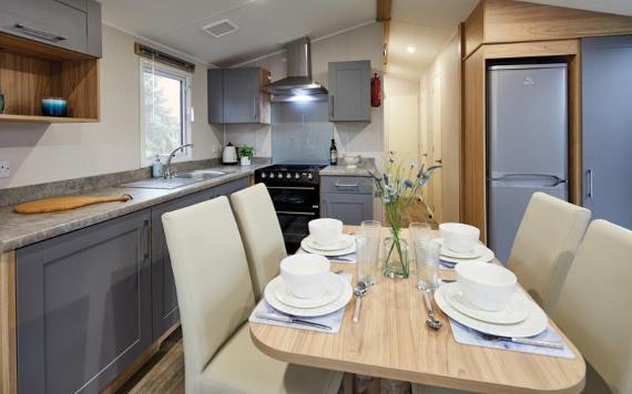 Dining table set up with vase of flowers inside Beacon Fell View caravan.