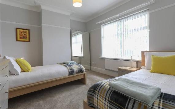 Bedzzz twin bedroom with grey and yellow decor.