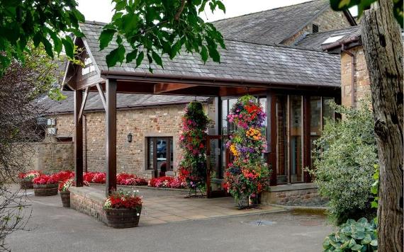 Entrance to Best Western Garstang Country Hotel surrounded by flowers.