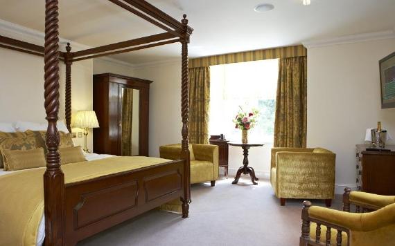 Villa Wrea Green hotel room with four poster bed and gold furnishings.