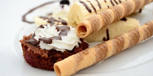 Page icon: Close up of chocolate and banana dessert with wafer straws on a white plate. Close up of chocolate and banana dessert with wafer straws on a white plate.
