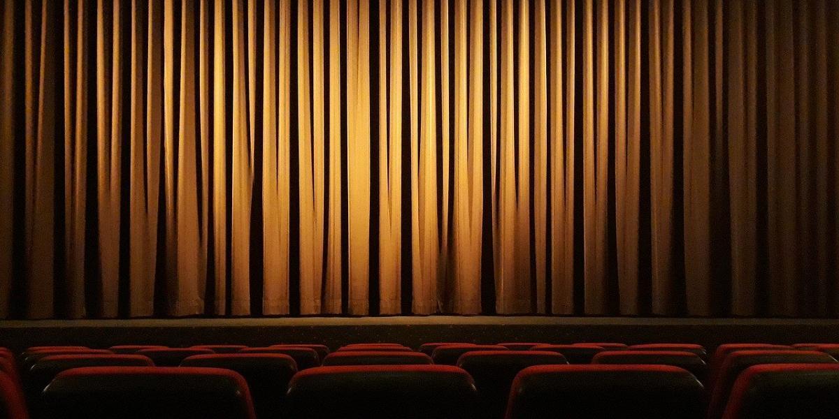 Theatre seats and stage with curtain closed.